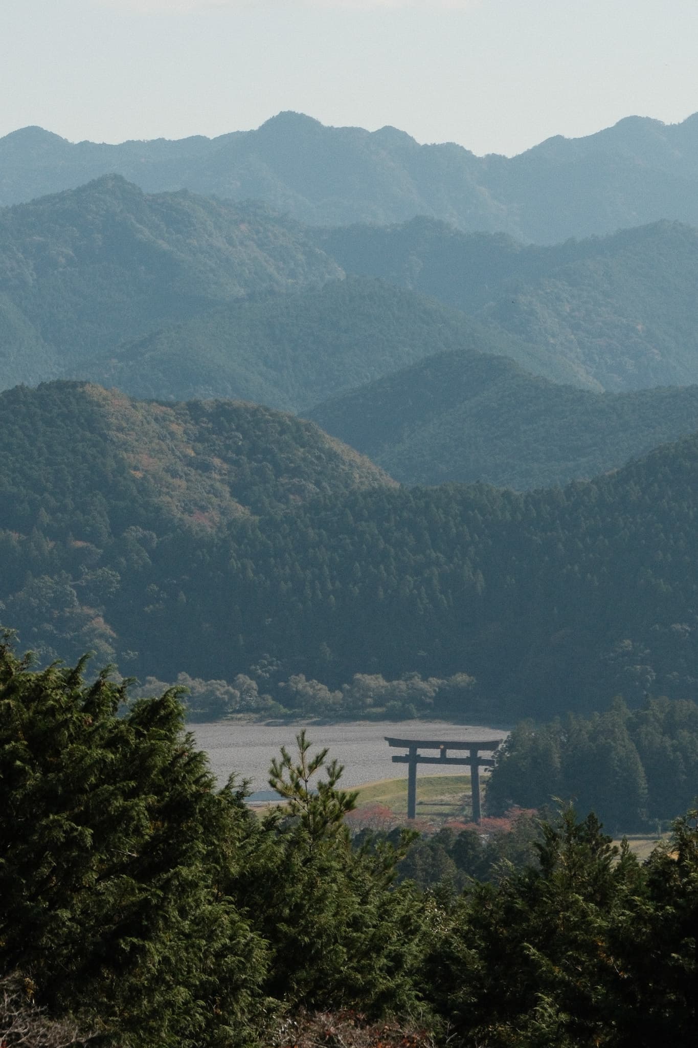 Layered mountain ridges with a torii gate in the valley