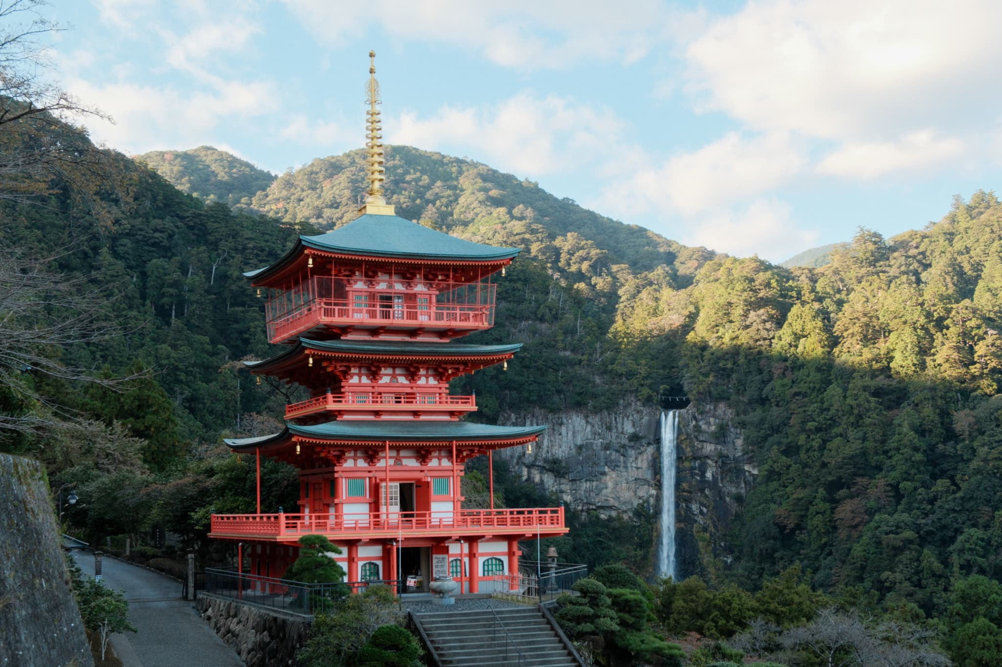 A red pagoda surrounded by forested mountains