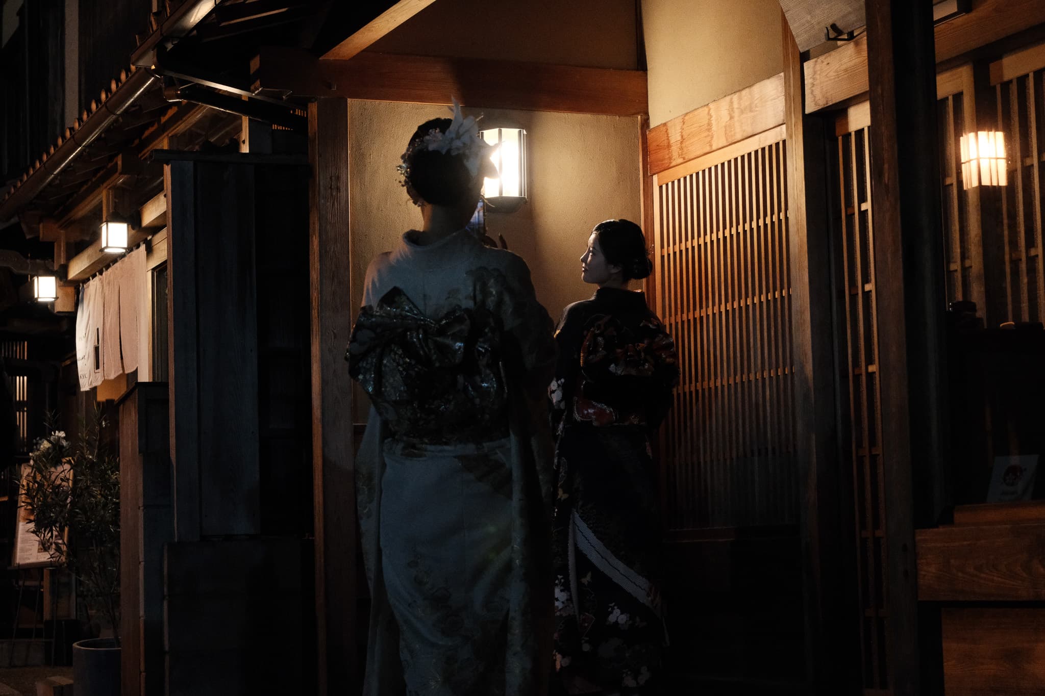 Two people in traditional clothing in a warmly lit passageway