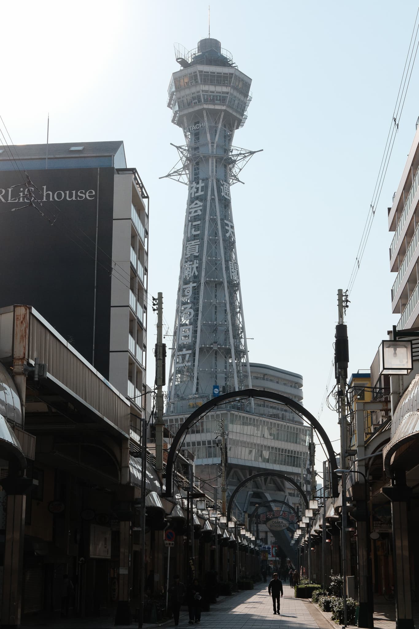 A tower rising above a narrow shopping street